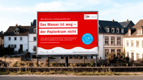 Out-of-Home-Motiv mit roter Fläche, Headline ‚Das Wasser ist weg – der Papierkram nicht‘ und Hinweis auf persönliche Beratung und Wiederaufbauhilfe.